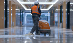 246117684_m Modern maintenance worker operating floor cleaning equipment in contemporary office building
